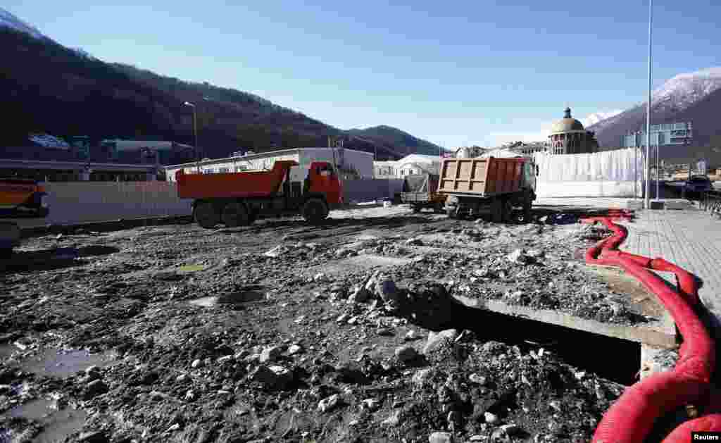 Construction trucks are parked next to the Gorki media center.