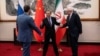 Chinese Foreign Minister Wang Yi welcomes Russian Deputy Foreign Minister Sergey Ryabkov and Iranian Deputy Foreign Minister Kazem Gharibabadi, before a meeting regarding the Iranian nuclear issue at Diaoyutai State Guest House on March 14, 2025, in Beijing, China
