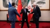 Chinese Foreign Minister Wang Yi welcomes Russian Deputy Foreign Minister Sergey Ryabkov and Iranian Deputy Foreign Minister Kazem Gharibabadi, before a meeting regarding the Iranian nuclear issue at Diaoyutai State Guest House on March 14, 2025, in Beijing, China