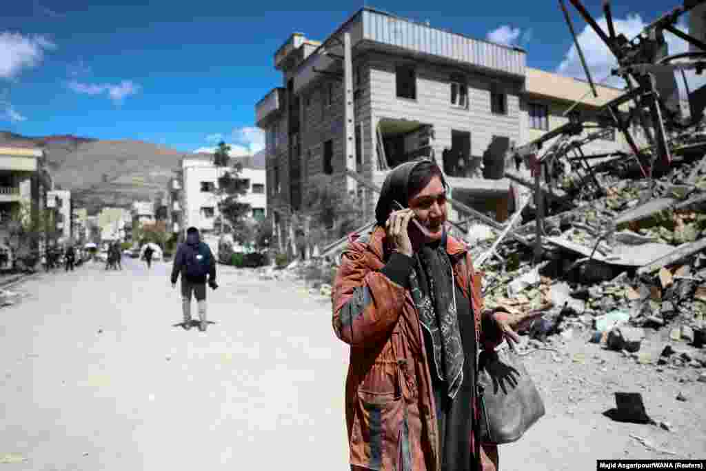 A woman walks past a destroyed building in Tehran on March 30. 