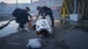 Police officers cover a dead body after two guided bombs hit a large construction supplies store in Kharkiv on May 25.