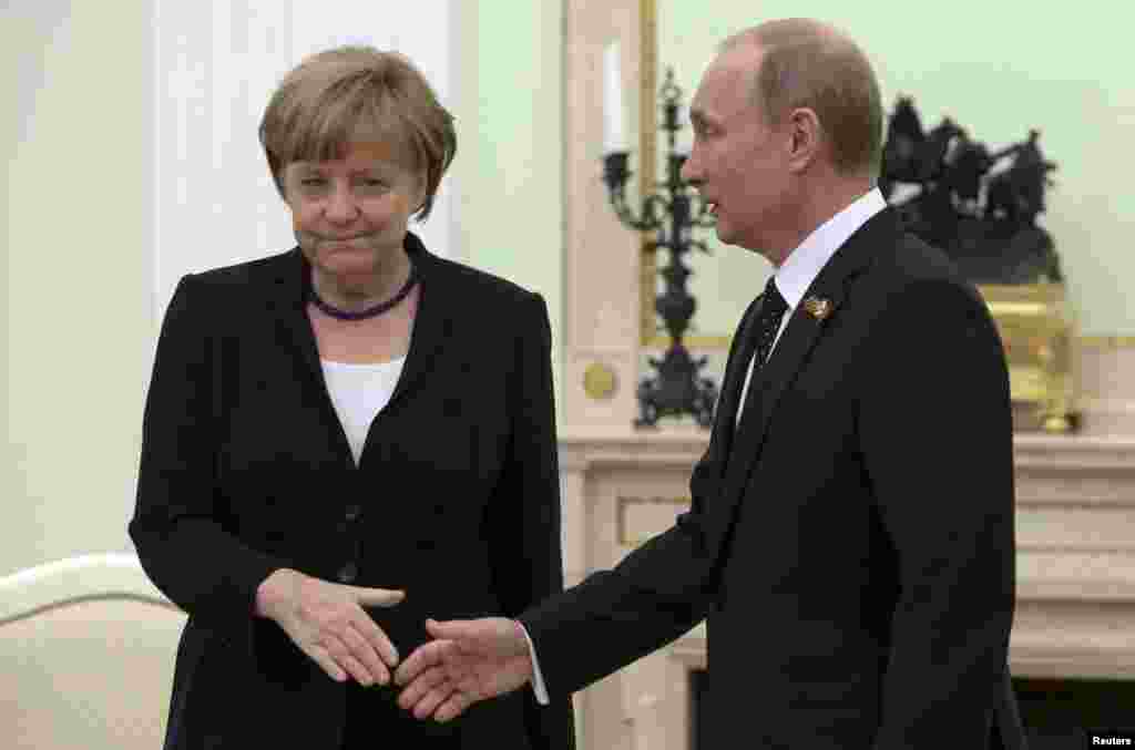 Russian President Vladimir Putin and German Chancellor Angela Merkel exchange an awkward handshake during a meeting at the Kremlin to discuss the Ukraine crisis. Merkel reiterated her calls to Putin to use his influence with pro-Russian separatists to end the conflict. (Reuters/Sergei Karpukhin)