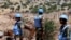 Soldiers from the United Nations Interim Forces in Lebanon (UNIFIL) stand along the barbed-wire fence marking the border with Israel. 
