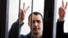 Belarusian opposition figure Paval Sevyarynets flashes the victory sign from the defendant's cage at a courthouse in the town of Mahilyou on May 25. 