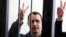Belarusian opposition figure Paval Sevyarynets flashes the victory sign from the defendant's cage at a courthouse in the town of Mahilyou on May 25. 