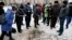 People look at the remains of a rocket that hit a residential street in the eastern town of Kramatorsk on February 10.