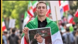 Ali Zarei, who has been sentenced to death, holding a photo of Hamidreza Rouhi, another person killed during protests in Iran. (file photo)