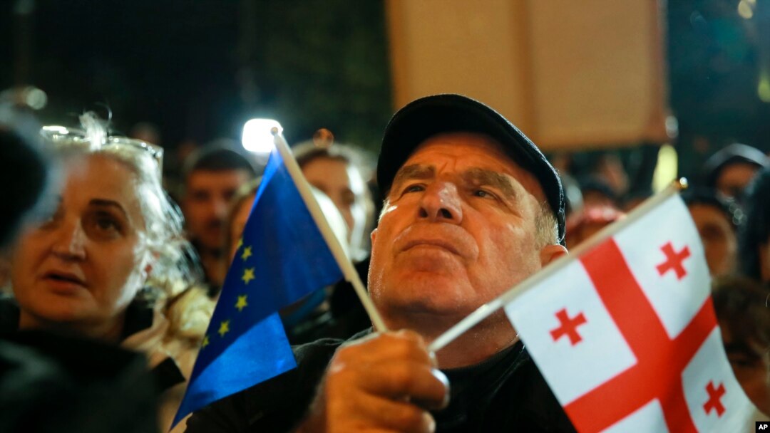 Manifestanți georgieni care au ieșit pe străzi în capitala Tbilisi în semn de protest față de presupusele nereguli la alegerile parlamentare.