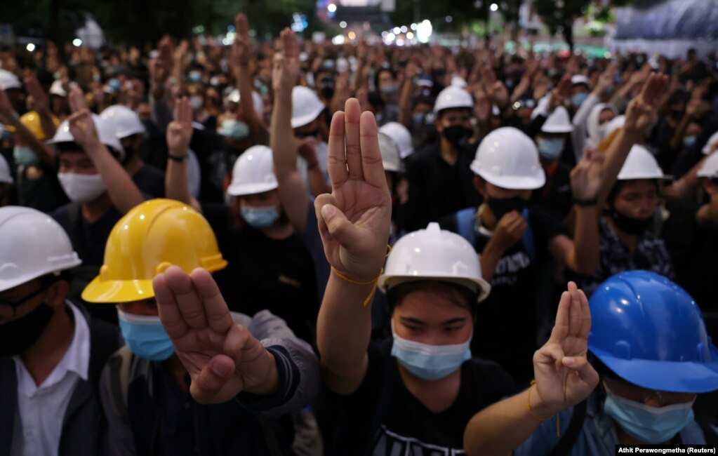 Демонстранти, які виступають за демократію, салютують трьома пальцями під час ходи до Будинку уряду в Бангкоку, 21 жовтня