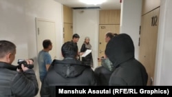 Тергеушілер белсенді Амангелді Жахиннің ұлының пәтерінің алдында тұр. Астана. 18 қараша, 2025 жыл.