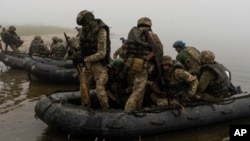 A group of Ukrainian marines sail from the riverbank of the Dnieper at the front line near Kherson on October 14.