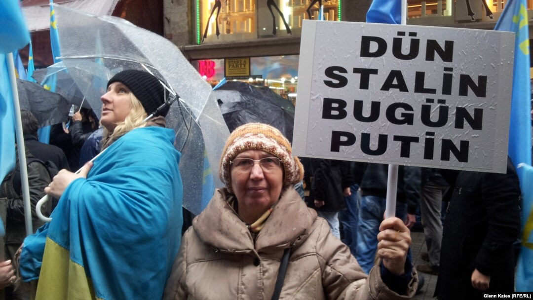 A woman holds a sign reading, "Yesterday Stalin, Today Putin" at a protest in Istanbul against Russian actions in Crimea.
