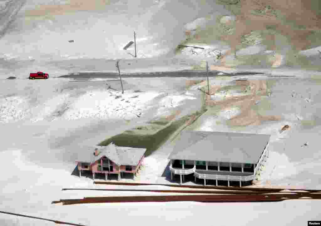 A truck drives along a road left covered by sand in Gulf Shores, Alabama, on August 30.