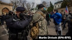 Police detain a protester as people gather in front of the Russian Embassy in Prague on April 18.