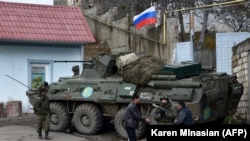 Men interact with a Russian peacekeeper in the town of Lachin situated along the corridor linking Nagorno-Karabakh with Armenia (file photo).