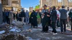 A woman cries in Nazarabad on April 6 following a strike on the city northwest of Tehran. 