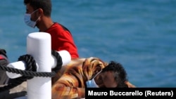 Migranti se odmaraju na brodu nakon što su stigli na južno ostrvo Lampedus, Italija (9. maj 2021.)