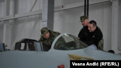 Serbian Defense Minister Aleksandar Vulin (in black) inspects a Russian MiG jet being upgraded at the Batajnica airfield.