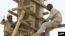 Iraqis work on a reconstruction project in Baghdad in August.