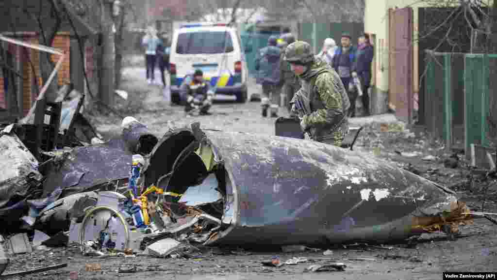 Vojnik ukrajinske vojske pregledava fragmente oborenog aviona u Kijevu, 25. februara 2022.