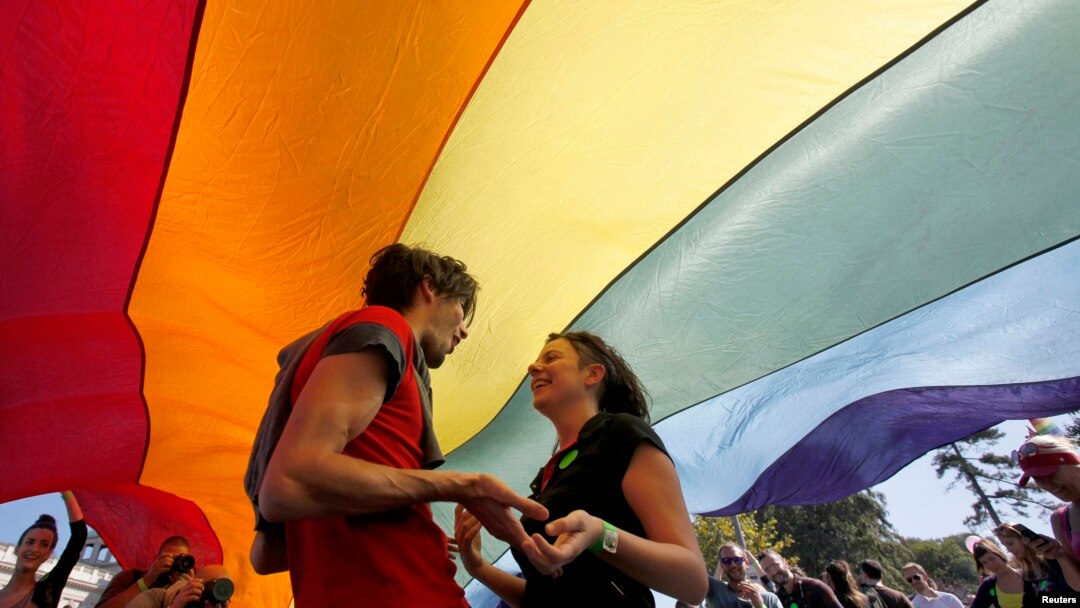 Serbia – Gay rights activists dance under a rainbow flag during a Pride march in Belgrade, September 28, 2014