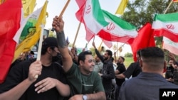 Ljudi, mašući zastavama Irana, Libana i drugih zemalja, okupljaju se u blizini zgrade iranske ambasade u Bagdadu 15. juna 2026. godine, tokom proslave nakon objave sporazuma o okončanju rata između Irana i SAD.