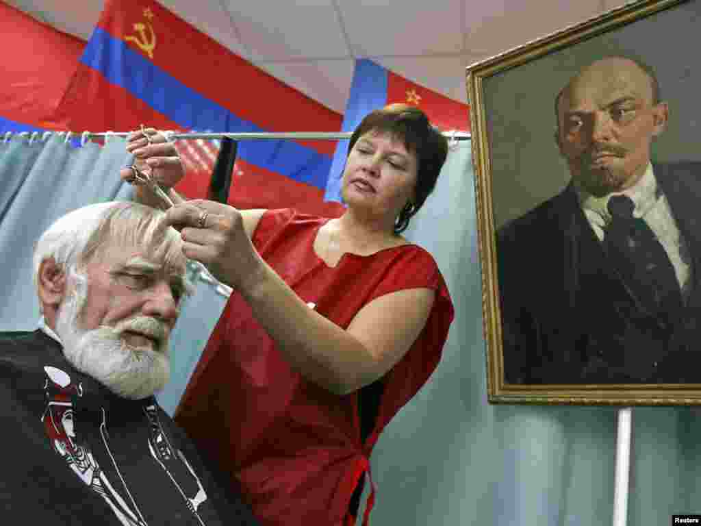 A hairdresser cuts a customer's hair at the "USSR" salon in the city of Barnaul in Russia's Altai region. The salon attracts elderly customers and veterans with its low prices and Soviet decor. Photo by Andrei Kasprishin for Reuters