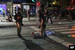 Persoane puse la pământ și reținute de forțele de ordine, Belgrad, 28 iunie 2025.