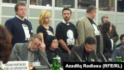 Varşava, ATƏT-in toplantısında azırbaycanlı siyasi məhbusların şəkilləri ilə köynək geyinib aksiya keçirən fəallar.