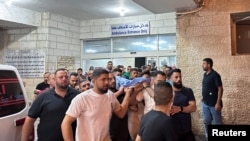 Trupul tânărului palestinian ucis în Cisiordania este scos dintr-un spital din Ramallah.