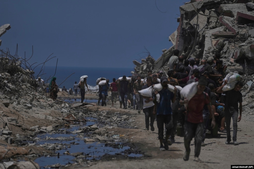 Palestinezë të tjerë duke bartur thasë me miell, më 22 korrik.