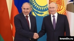 Russian President Vladimir Putin (right) welcomes Armenian Prime Minister Nikol Pashinian in St. Petersburg in December 2025. The EU has warned of Russia's "destabilizing tactics" in Armenia ahead of parliamentary elections in June. 