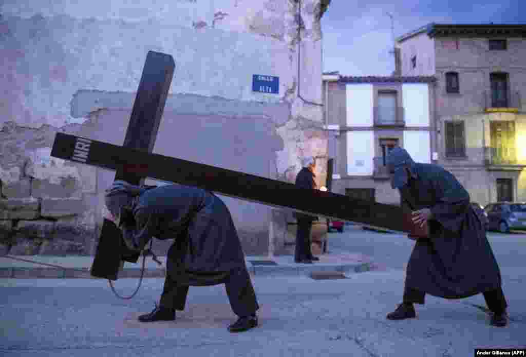 A penitent tied with a rope round his neck carries a cross during an Easter Holy Week procession in the northern Spanish village of Sietamo. (AFP/Ander Gillenea)