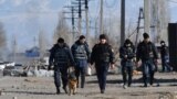 Kazakhstan - Police officers walk along road in the village of Blas-Batyr some 250 kilometres from Almaty on February 8, 2020. - Eight people were killed, dozens hurt and property burned during clashes between ethnic Kazakhs and members of the Dungan mino