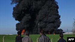 Люди спостерігають за димом на околиці Ербіля, столиці Іракського Курдистану, після ймовірного удару безпілотника, 1 квітня 2026 року