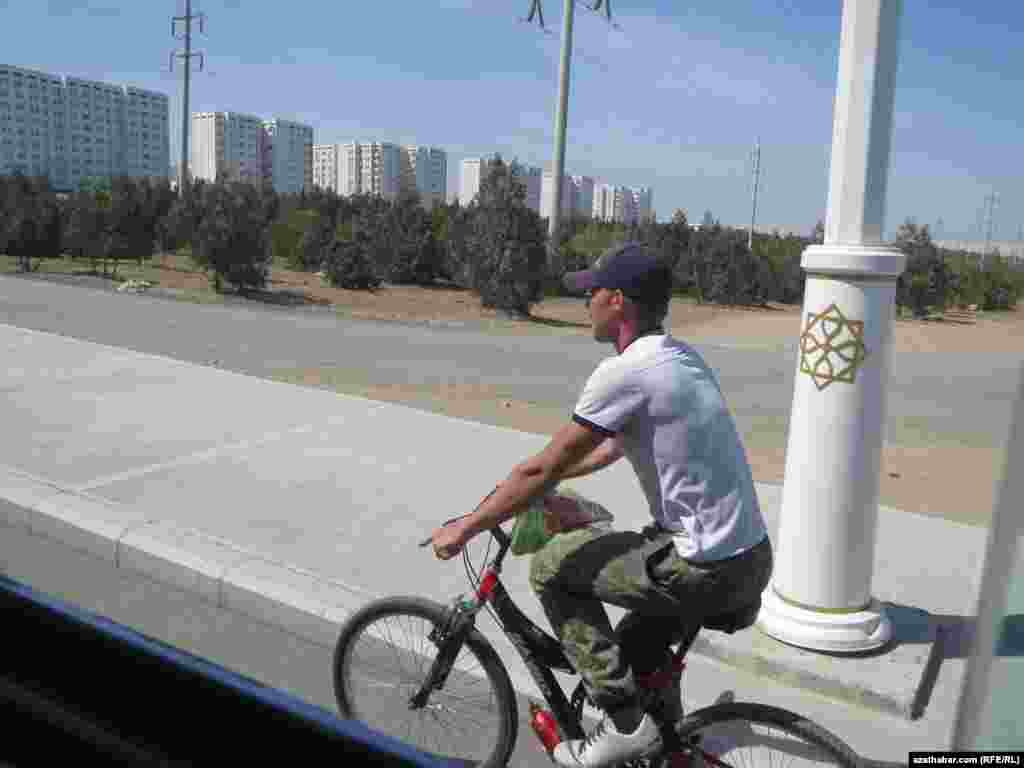 Aşgabatda welosiped sürüp barýan bir raýat.