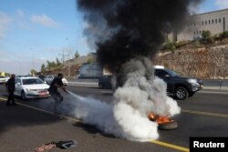 Një person e shuan zjarrin gjatë protestave antiqeveritare në ditën e protestave për shënimin e 9-mujorit të sulmit të 7 tetorit, Shoresh, Izrael, 7 korrik 2024.