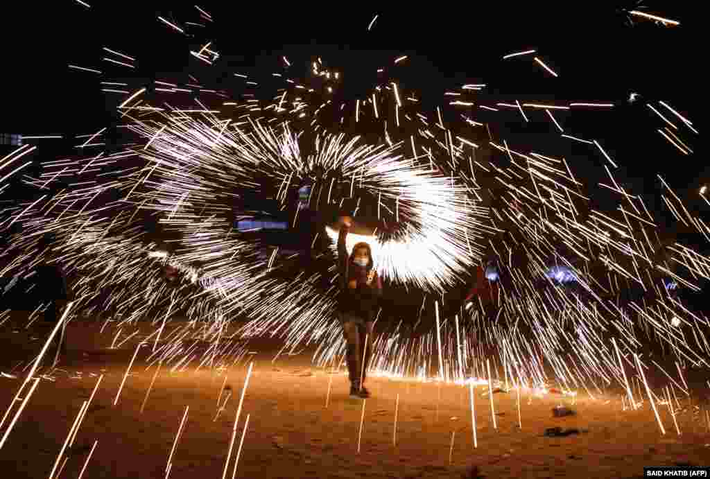 Палестинец запускает фейерверк во время празднования начала Рамазана в городе Рафах на юге сектора Газа. 12 апреля 2021 года.