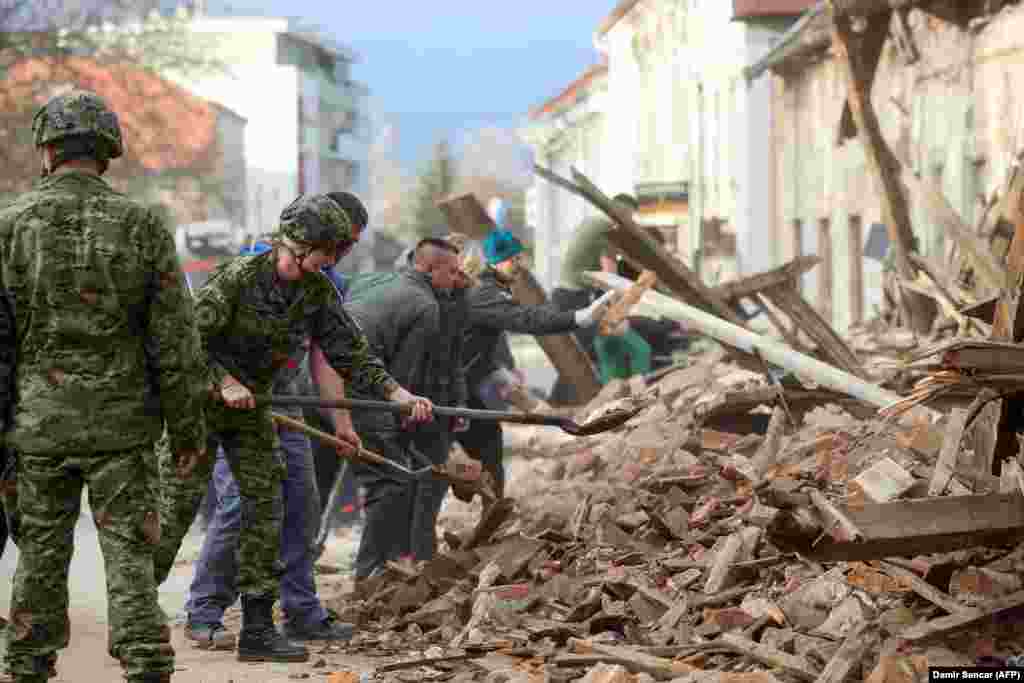 Ushtarët dhe qytetarët në qytetin Petrinja, pastrojnë afër një ndërtese të dëmtuar nga tërmeti. 29 dhjetor, 2020 &nbsp;