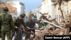 Horvát katonák takarítják el a romokat Petrinjában, mintegy 50 km-re Zágrábtól, miután a várost 2020. december 29-én 6,4-es erősségű földrengés sújtotta