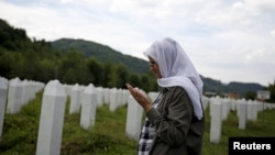 Hajra Catic prays near the grave of her husband in Potocari on June 23. She is still looking for her son, Nihad, who was 26 when Srebrenica fell.