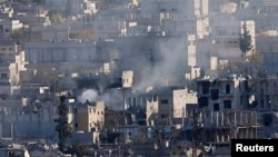 Smoke rises over an eastern Kobani neighborhood damaged by fighting between Islamic State militants and Kurdish forces on November 18.