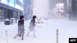 په نیو یارک ښار کې دوه ښځې د سختې واورې پر مهال له سړکه تېرېږي - د جنورۍ ۲۵مې انځور. 