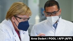 Angela Merkel și Ugur Sahin, șeful companieie de biotehnologie BioNTech, Marburg, vestul Germaniei, 19 august 19 2021. (Foto de Arne Dedert / POOL / AFP)