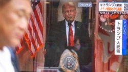 A man walks past a television screen showing a live broadcast of US President Donald Trump delivering an address on the war with Iran, in Tokyo on April 2.