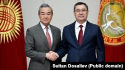 Chinese Foreign Minister Wang Yi (left) meets Kyrgyz President Sadyr Japarov in Bishkek on November 19 during a three-country tour of Central Asia. 
