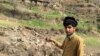 A resident points to the damaged site where Indian military aircrafts released payload on February 26.