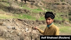 A resident points to the damaged site where Indian military aircrafts released payload on February 26.