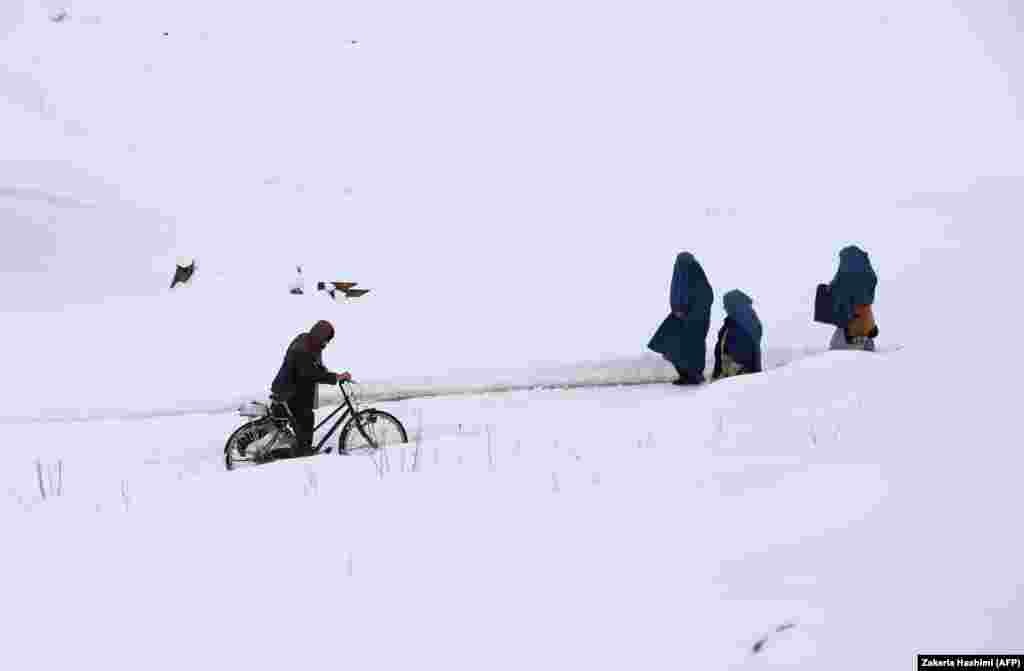 Afghan residents walk through a section of the old city amid snowfall in Ghazni. (AFP/Zakeria Hashimi)