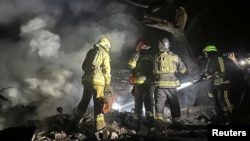 Ukrainian firefighters work on in a residential area hit by a Russian air strike on September 23. 